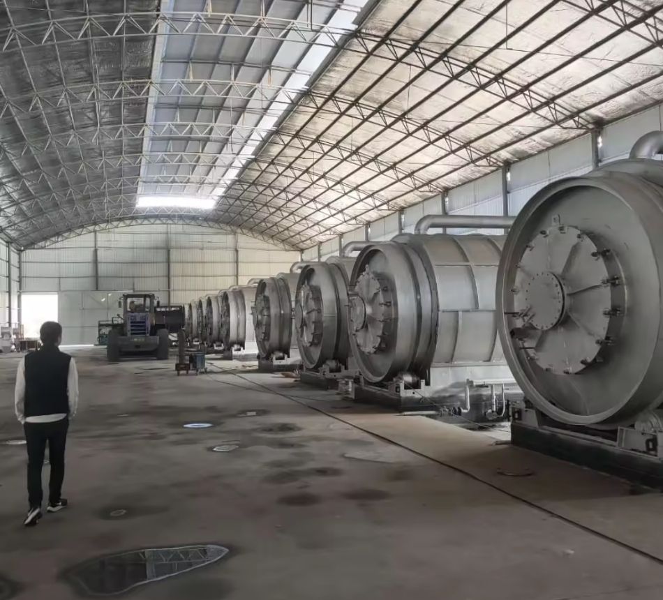 Industrial site with workers walking towards large structures under a blue sky with scattered clouds.